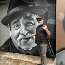 David Favela in front of a mural of the late Chunky Sanchez, a local Chicano musician